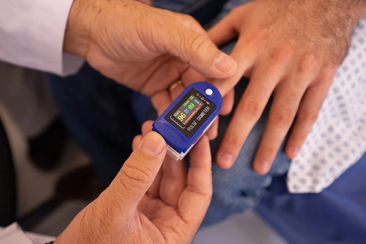 Person holding a pulse oximeter