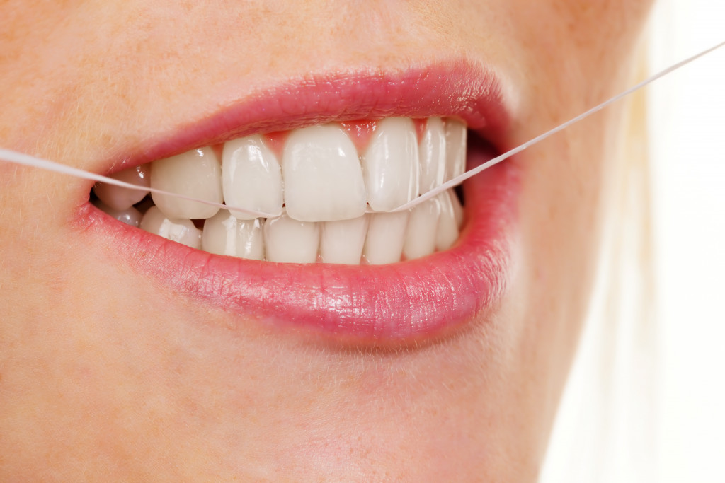 woman wearing lipstick flossing