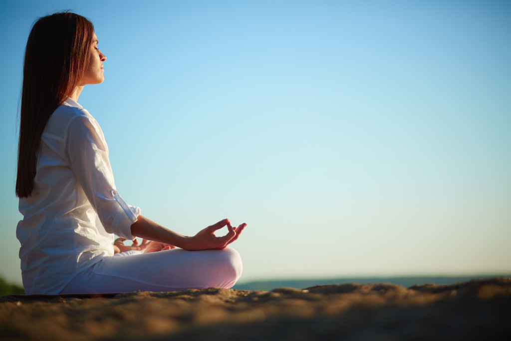 woman meditating near the beach