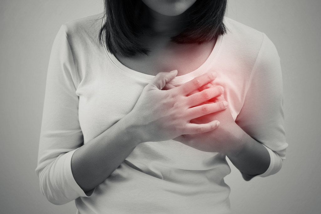 Woman is clutching her chest, acute pain possible heart attack