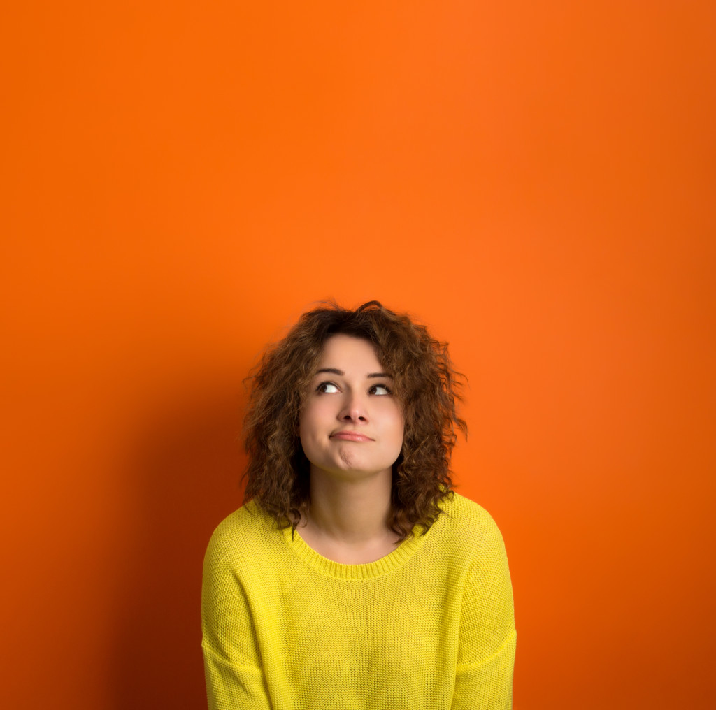 woman in yellow shirt thinking