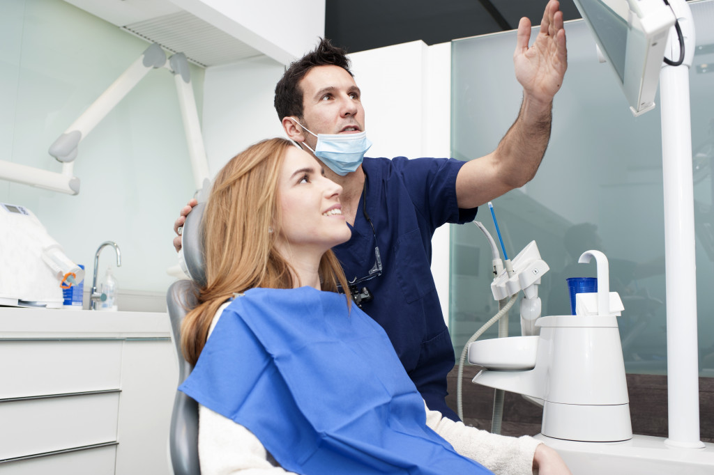 Dentist pointing to his patient about the diagnosis