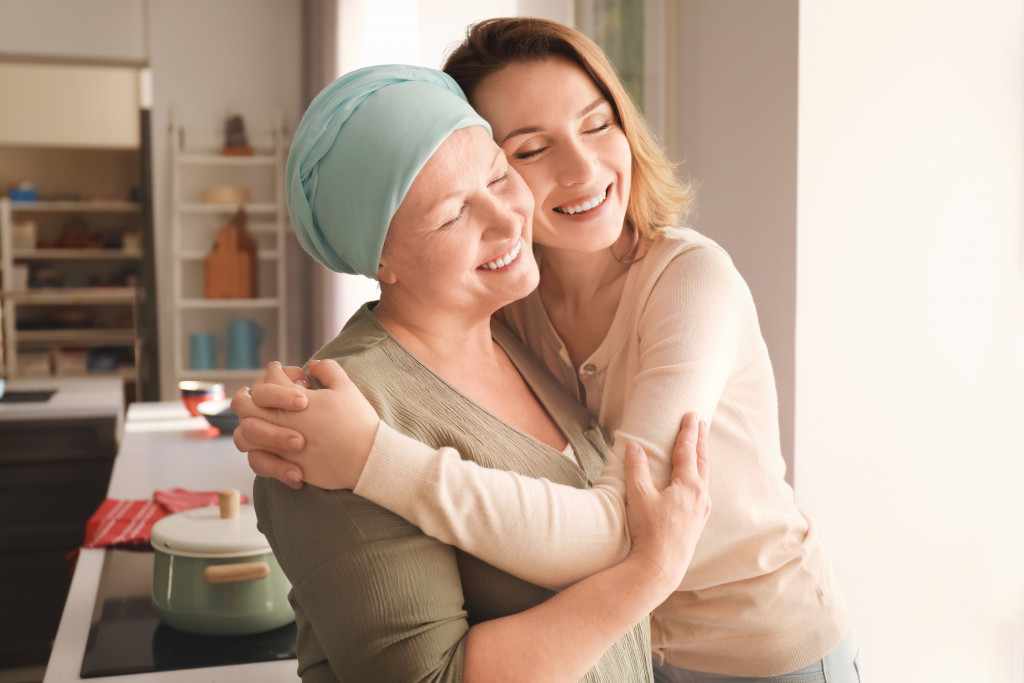 Woman hugging another woman who's undergoing cancer treatment