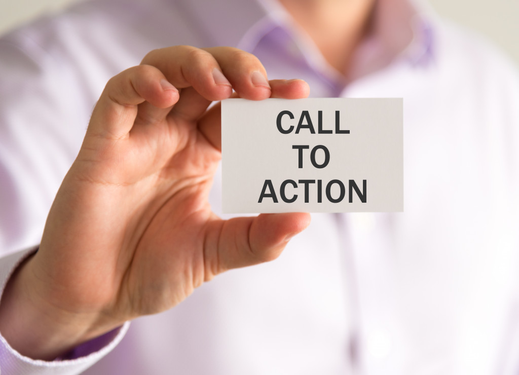 A closeup of a hand holding a card that states “call to action.”