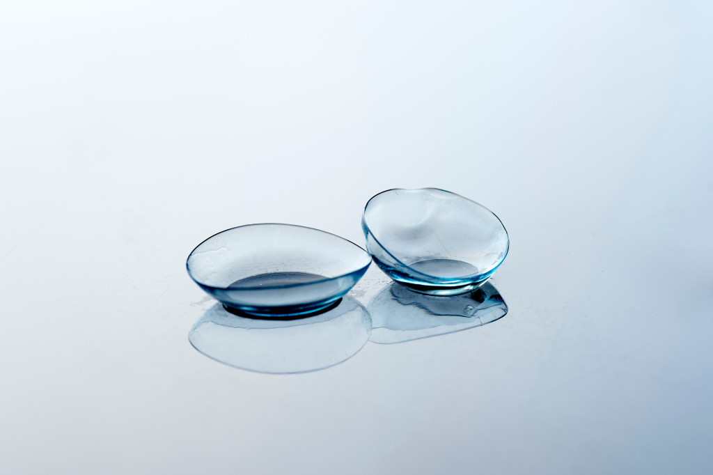 A pair of clear contact lenses on a reflective surface