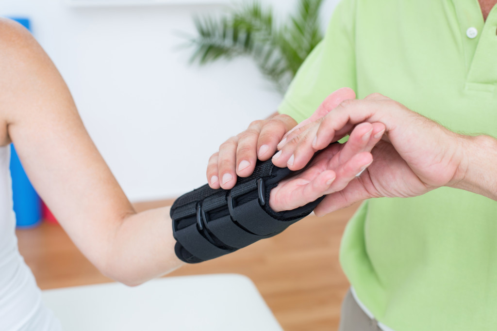 doctor examining his patients wrist in medical office