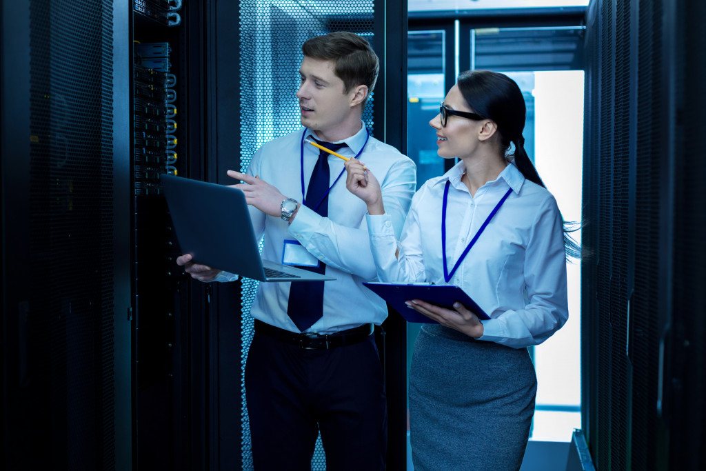 a male and female IT experts checking data servers