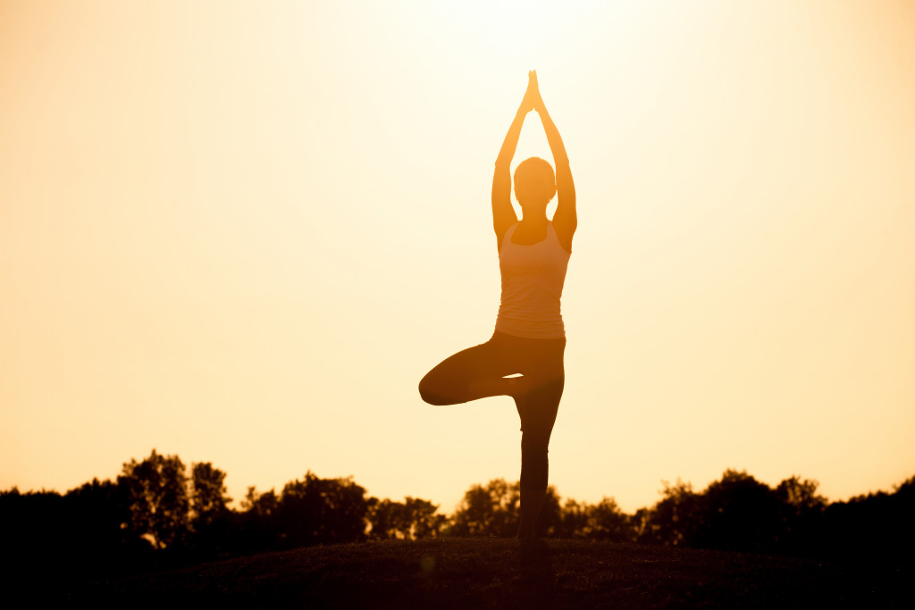 woman doing yoga against sunlight