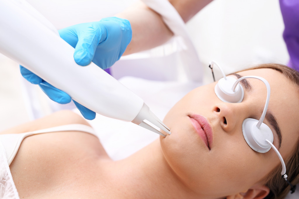 A woman getting facial laser procedure in a med spa