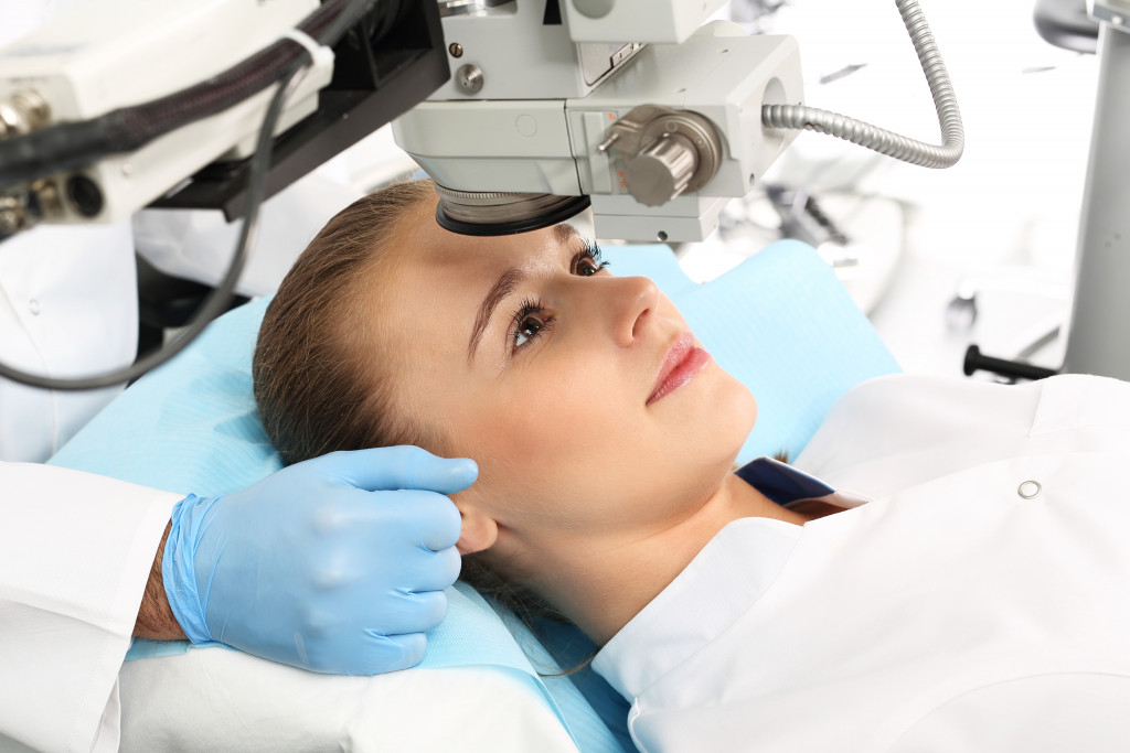 a woman staring at a robotic laser during a surgery