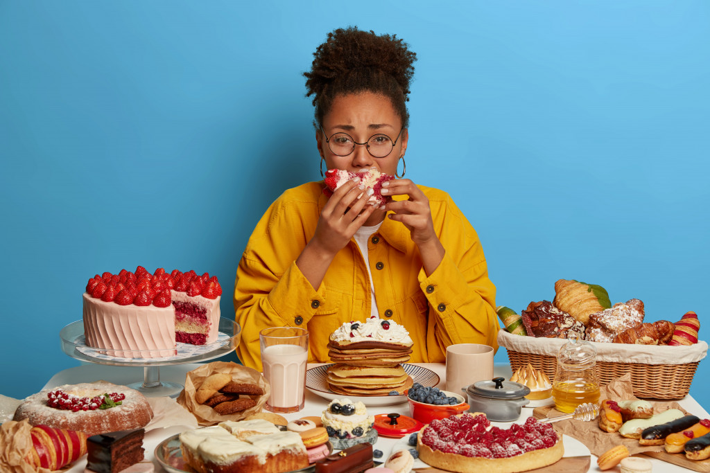 woman with too many desserts on the table