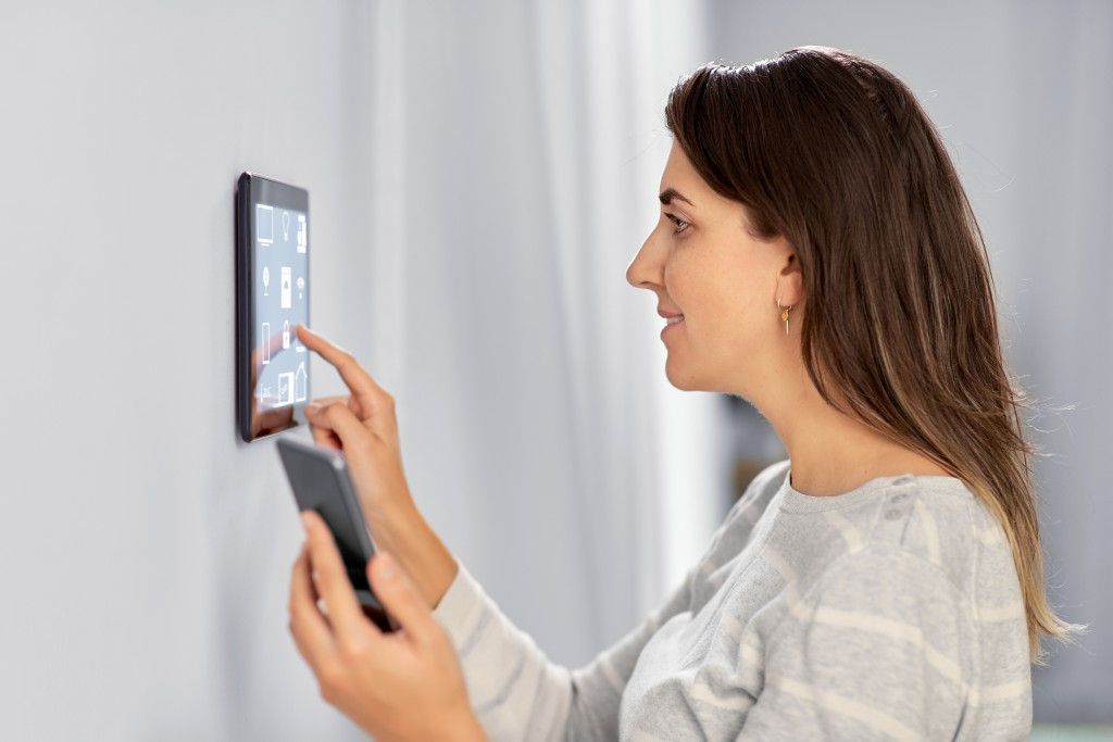 a homeowner using her control for smart home system